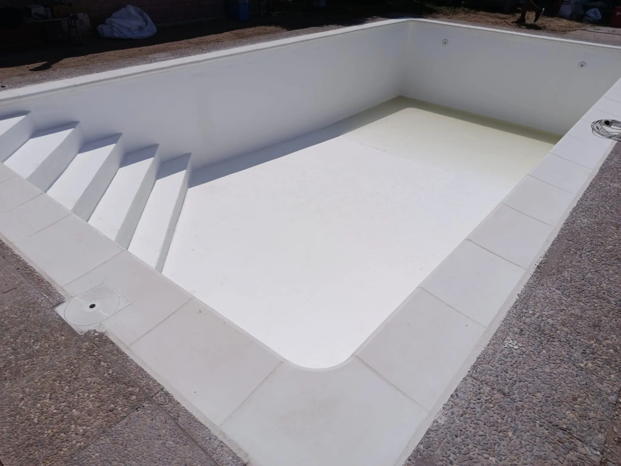 Escalera de obra en esquina y coronación técnica en piscina en Zaragoza