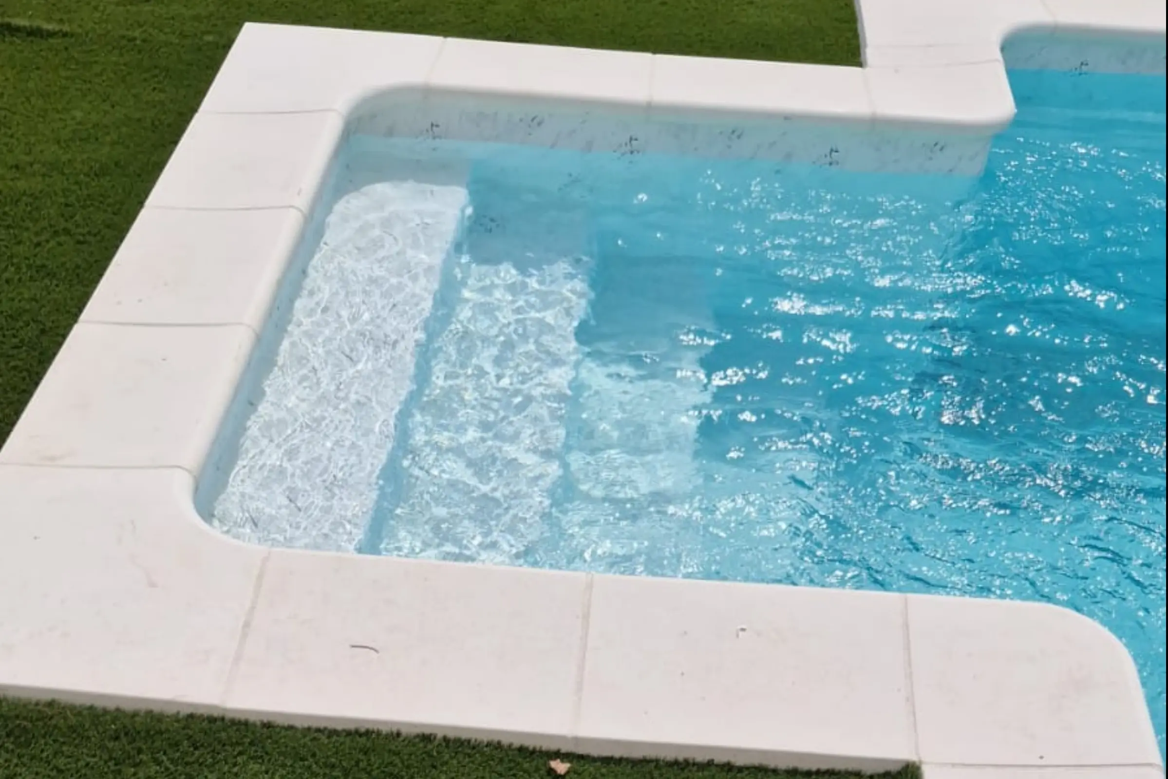 Piscina con banco sumergido y amplios escalones integrados de obra